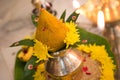 Decorative metal kalasha (metal pot) with green leaves and coconut - Indian wedding ceremony