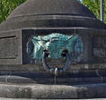 Decorative metal mooring ring in the shape of an enigmatic face set into a cylindrical stone housing