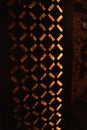 Decorative metal partition with geometric holes, illuminated brick wall. Restaurant decor