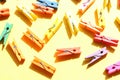 Decorative multicolored wooden clothespins on a yellow background. Flat lay composition Royalty Free Stock Photo