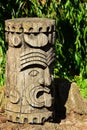 Decorative native american wooden head or totem, propably Aztec or Mayan, displayed on stone pedestal