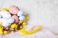 Decorative nest with many painted Easter eggs on light textured background, closeup. Space for text Royalty Free Stock Photo