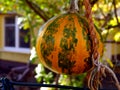 Decorative orange and green gourd in exterior space hangign on Jute hemp string