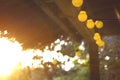 Decorative outdoor string lights hanging on the porch at the sunset