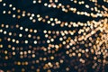 Decorative outdoor string lights at night time, Defocused Background, night city life backdrop, party time with Yellow bokeh balls Royalty Free Stock Photo