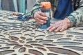 Decorative partition wall with floral pattern. Carpenter milling holes in MDF with a hand electric router machine Royalty Free Stock Photo