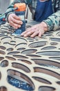 Decorative partition wall with floral pattern. Carpenter milling holes in MDF with a hand electric router machine Royalty Free Stock Photo