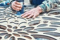 Decorative partition wall with floral pattern. Carpenter milling holes in MDF with a hand electric router machine Royalty Free Stock Photo