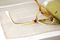 DECORATIVE PATTERN ON OLD BROKEN READING GLASSES ON AN OPEN BOOK