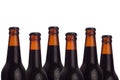 Decorative pattern of sealed brown beer bottles with porter and water drops on white background. Royalty Free Stock Photo