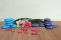 Decorative pebbles stacked in a Zen life fashion on a bamboo wooden board with a pink flower and an orchid on a green background Royalty Free Stock Photo