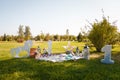 Decorative photozone for 1 year old boy birthday outdoors. Plaid, cushions, lanterns, number one, rocking horse on green lawn Royalty Free Stock Photo