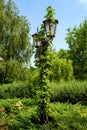 Decorative pillar with street lighting lantern in the city park.