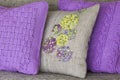 Decorative pillows - knitted violet with braids pillow and pillow made of linen fabric with colorful embroidery Royalty Free Stock Photo