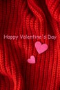 Decorative pink heart on a red knitted background, top view. Lettering Happy Valentine`s Day
