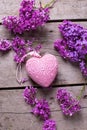 Decorative pink heart and violet lilac flowers on aged wooden