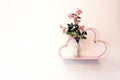 Decorative pink shelf on white wall with glass vase and pink bright flowers, modern romantic decoration interior Royalty Free Stock Photo