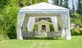 Decorative place for ceremonies or entertainments. Outdoor reception under tents and trees.