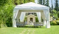 Decorative place for ceremonies or entertainments. Outdoor reception under tents and trees.