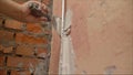 Decorative plaster coating. Man does ragged texture on the wall using a spatula. plaster application on the wall Royalty Free Stock Photo