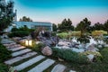 Decorative pond with artificial waterfall in courtyard of country house at summer sunset Royalty Free Stock Photo