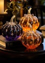 Decorative pumpkins of different sizes and shapes made of colored glass. Stylish Halloween decor. White blurred living