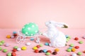 Decorative rabbit with Easter egg and sweets on pink background Royalty Free Stock Photo