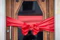 Decorative Red Ribbon Bow Adorning a Wooden Door for a Festive Celebration Royalty Free Stock Photo