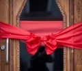 Decorative Red Ribbon Bow Adorning a Wooden Door for a Festive Celebration Royalty Free Stock Photo