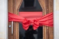 Decorative Red Ribbon Bow Adorning a Wooden Door for a Festive Celebration Royalty Free Stock Photo