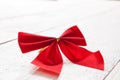 Decorative red ribbon and bow on a background of white painted r Royalty Free Stock Photo