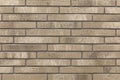 Decorative Relief Facing Plates Imitating beige Brick On The Wall. Royalty Free Stock Photo