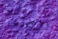 Abstract texture of concrete wall covered uneven decorative stucco and painted bluish-purple paint