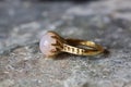 decorative ring with natural mineral moon stone gemstone on grey neutral rocky background