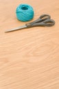 decorative rustic cyan yarn ball and scissors on a wooden tabletop