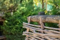 Decorative rustic fence of interwoven wooden bars in garden