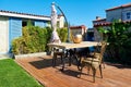 Decorative rustic wooden table and vintage chairs at the exterior patio of a villa