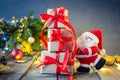 Decorative Santa Claus carrying presents on the festive dark background with Christmas tree, lights and decor on the old wooden bo Royalty Free Stock Photo