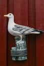 Decorative seagull figurine on a red wooden wall Royalty Free Stock Photo