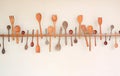 Decorative set of wooden kitchen utensils hanging on white wall background Royalty Free Stock Photo