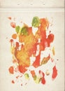 Decorative sheet of old vintage paper stained with red, orange and green drops of watercolor paint. Blank page of aged brown paper