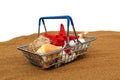 A decorative shopping basket with various shells stands on the sand. Royalty Free Stock Photo