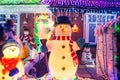 Decorative snowmen with lights and shiny outdoor Christmas decorations at night. Merry Xmas and New Year outside exterior decor. Royalty Free Stock Photo