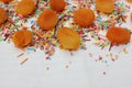 Decorative sprinkles border and dried apricots on white background. Multicolor Sugar confectionery powder and dried apricots in th Royalty Free Stock Photo