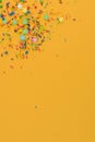 Decorative sprinkles border on yellow. Copy space. Royalty Free Stock Photo