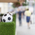 Decorative stand in the form of the classic football ball in the net on the green grass. Ornaments of city streets Royalty Free Stock Photo