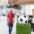 Decorative stand in the form of the classic football ball in the net on the green grass. Ornaments of city streets Royalty Free Stock Photo