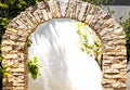Rustic stone arch with plants and white shaded background Royalty Free Stock Photo