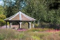 Decorative tiled gazebo structure in ornamental flower garden