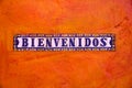 Tiles with letters spelling BIENVENIDOS WELCOME on orange back